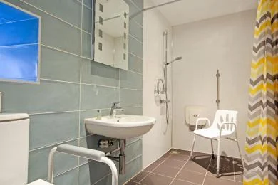 The level-access wet room shower in Morridge View's ground-floor accessible bedroom, with seat and handrails