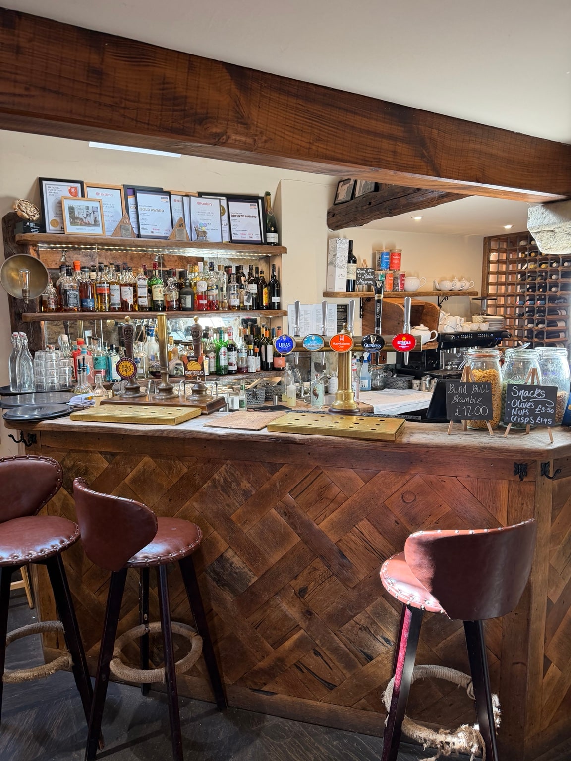 The bar at the Blind Bull, with reclaimed parquet, hand pumps and a shelf of awards