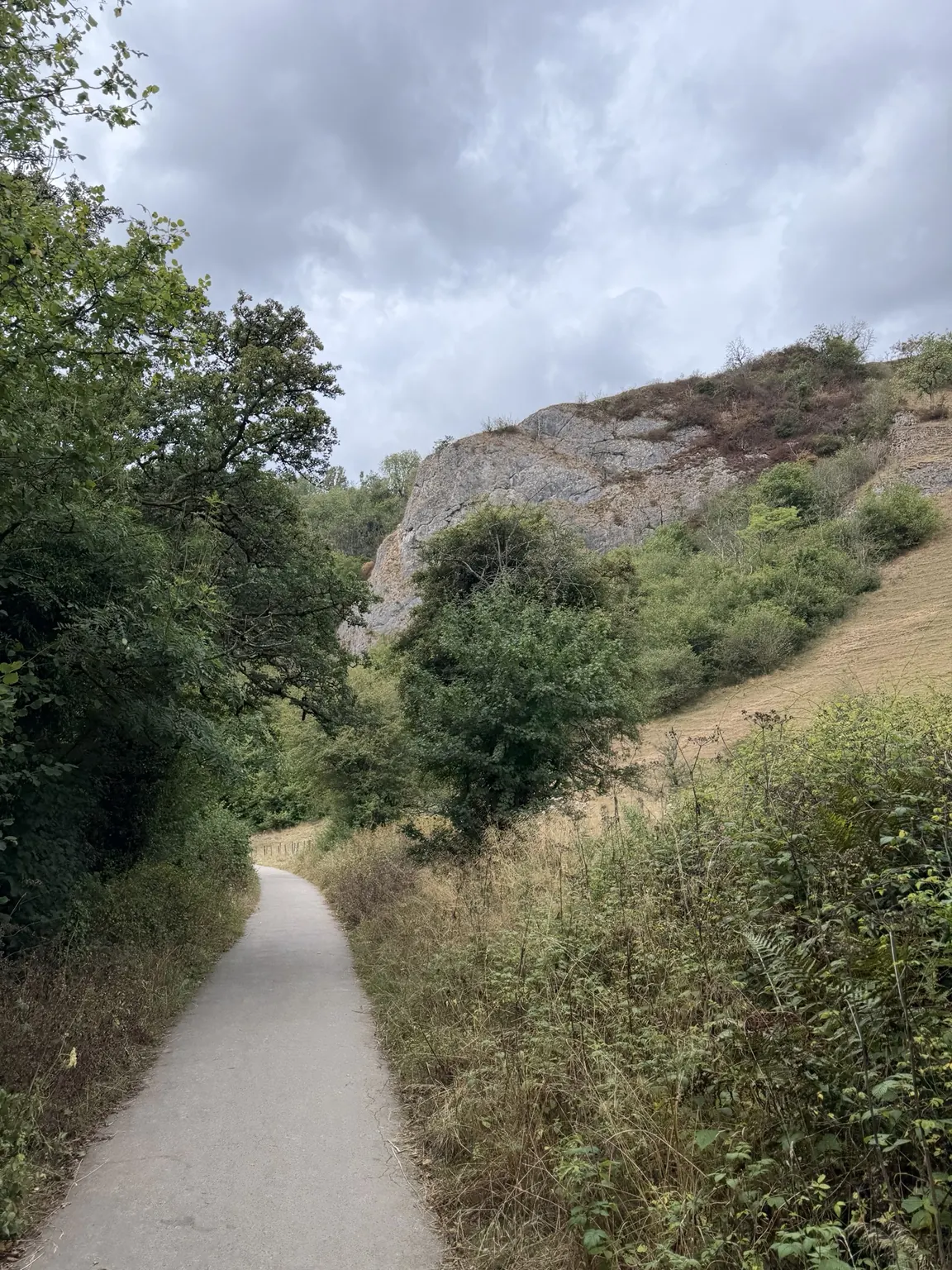 The surfaced Manifold Valley path beneath a limestone crag