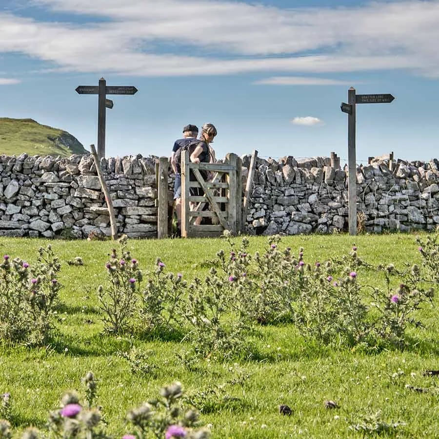 Walkers at a stone stile on the moorland footpaths nearby