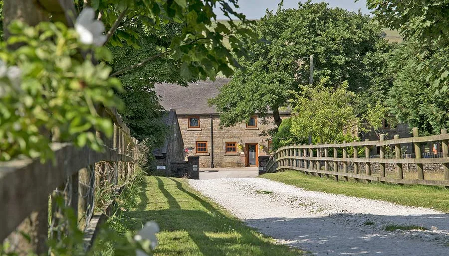 Exterior of Mixon View, a 17th-century stone barn, seen down the approach lane