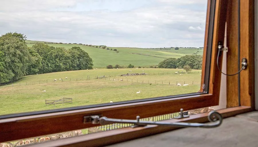 The view across farmland from Mixon View, framed by the window